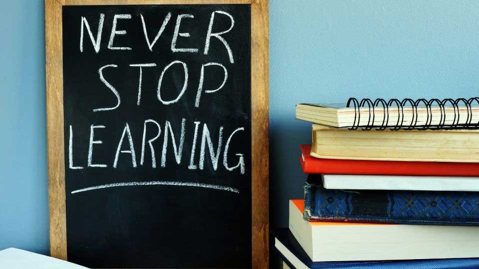 Never stop learning message next to books