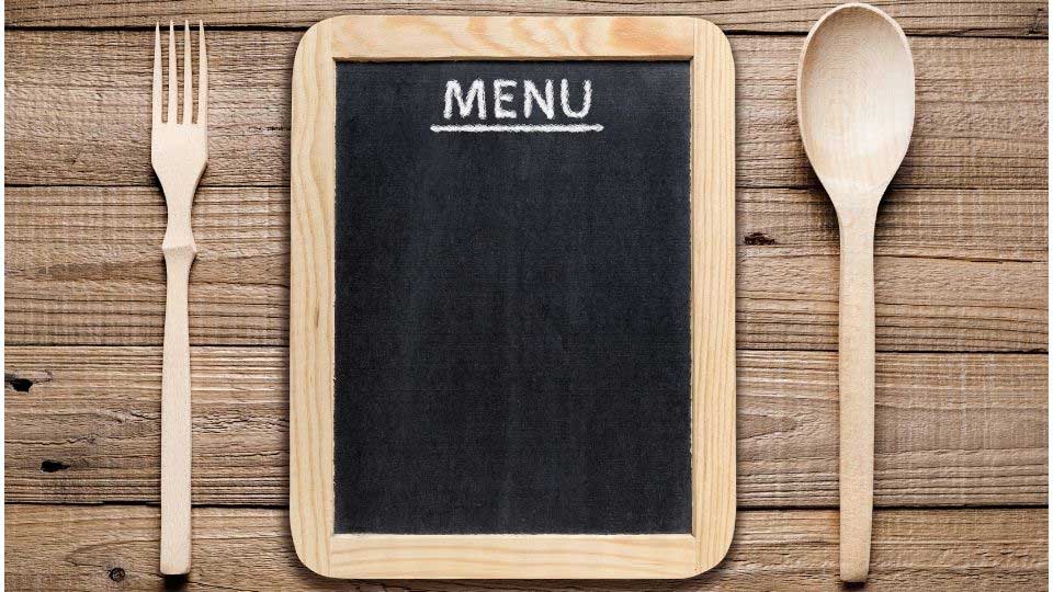 Menu, wooden fork and spoon on table